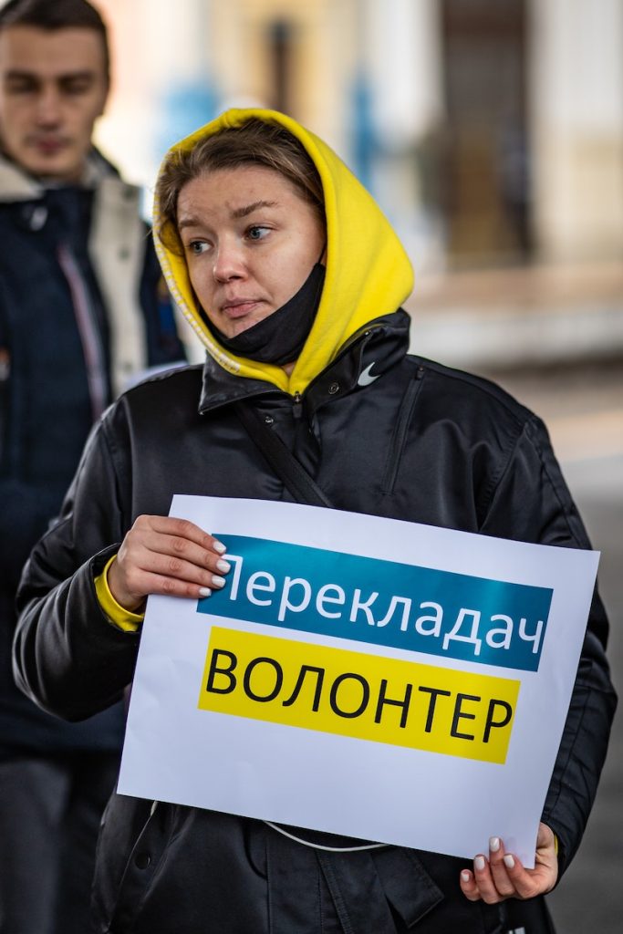 A Translator in a Yellow Hoodie Holding a Placard